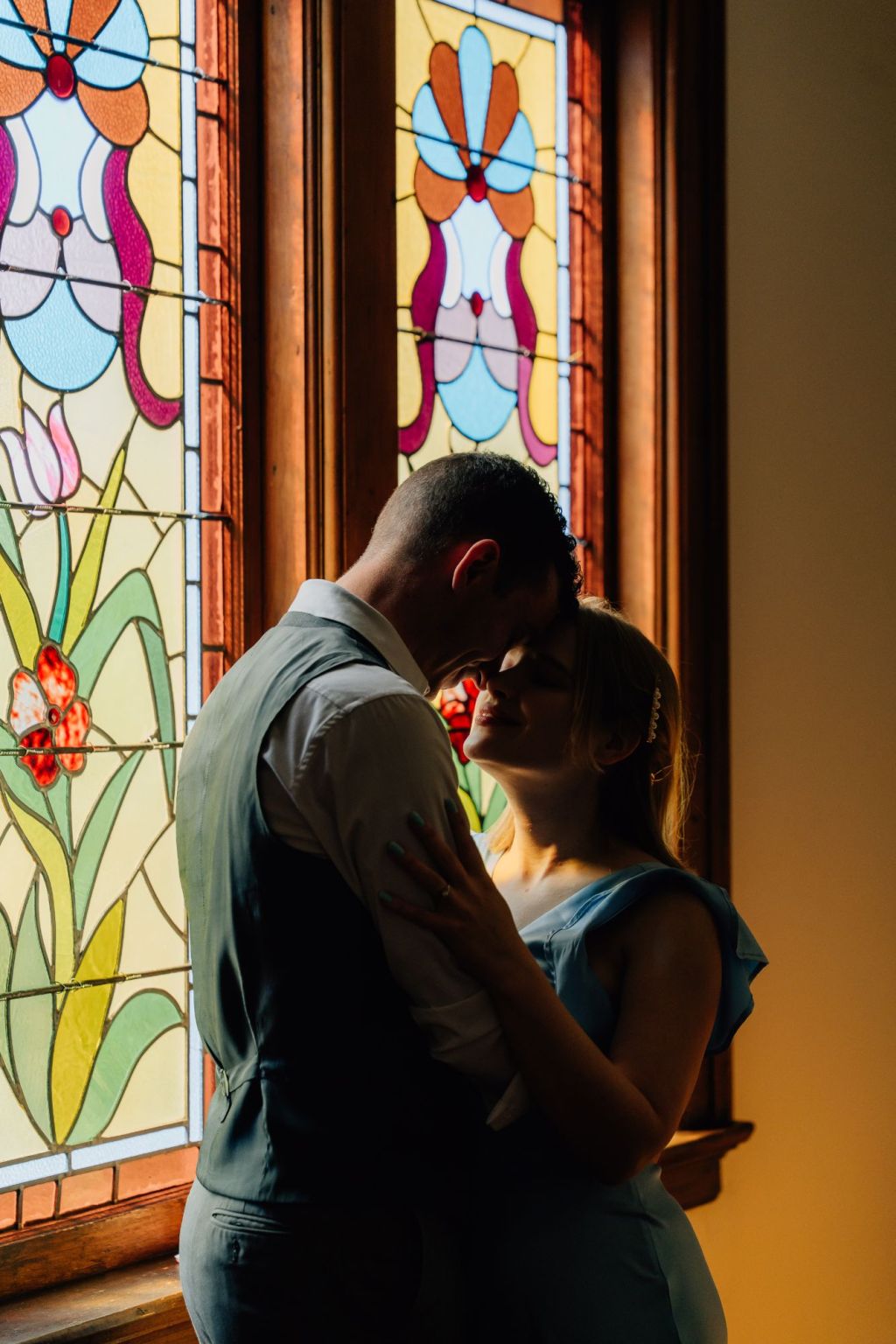 couple standing in front of stained glass window